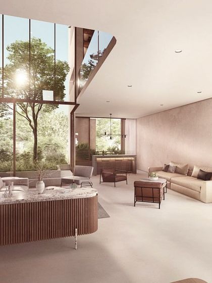 The living space in 'The Nest' vertical villa, where a double-height window frames a central courtyard tree. The design uses a refined palette of materials to create an atmosphere of understated luxury and warmth.
