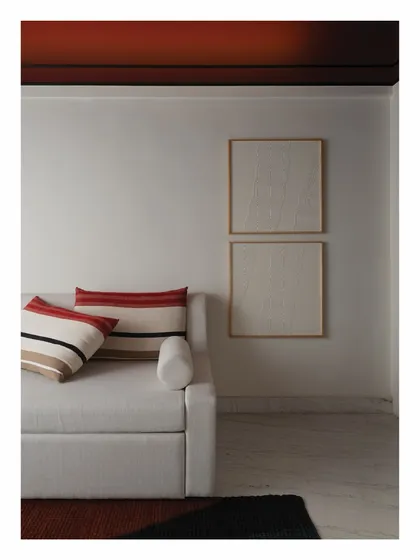 This guest room features a dramatic Marsala red curved ceiling, detailed with a stark black molding. We designed a sleek, indirect lighting system using a custom wooden rod to cast a dim, warm glow, creating a modern and moody ambiance.