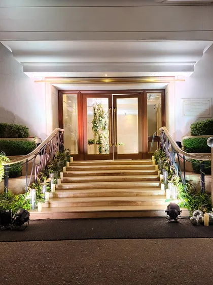 We transform every part of the venue, including staircases. This grand staircase is lined with fresh greenery and subtle uplighting, creating an elegant path for guests.