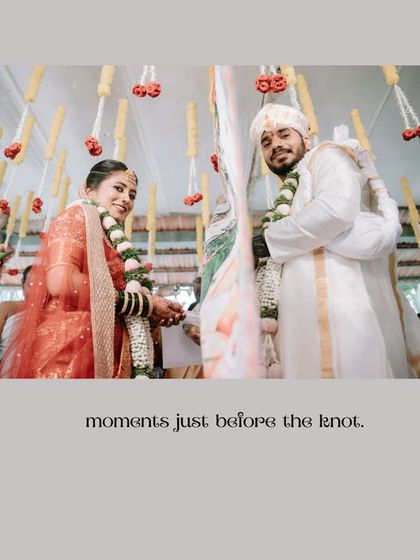 "Moments just before the knot." A beautiful, anticipatory shot of the couple during their ceremony, framed by hanging floral decorations.