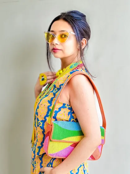 A side view highlighting the multi-colored, beaded bag. A statement bag can be the centerpiece of your outfit.