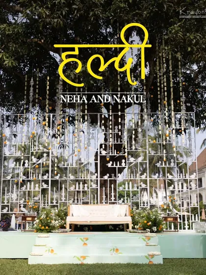 The main stage for the Haldi ceremony, beautifully decorated with hanging floral strings and a backdrop of white bird silhouettes.