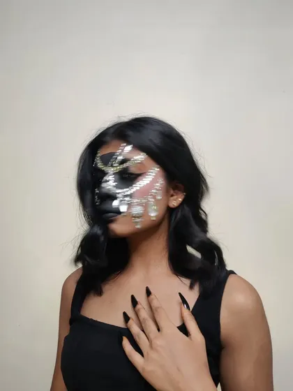 I love how the sharp, press-on nails add another layer of drama to this dark, embellished makeup look.
