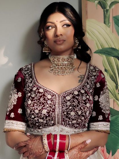 Elegance personified. For Kavi, we chose a classic look with beautifully defined eyes and soft contouring to complement her regal velvet lehenga, letting her natural grace be the focus.