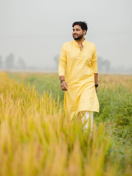 A beautiful portrait of the groom walking through the fields, a serene and happy moment before the wedding.