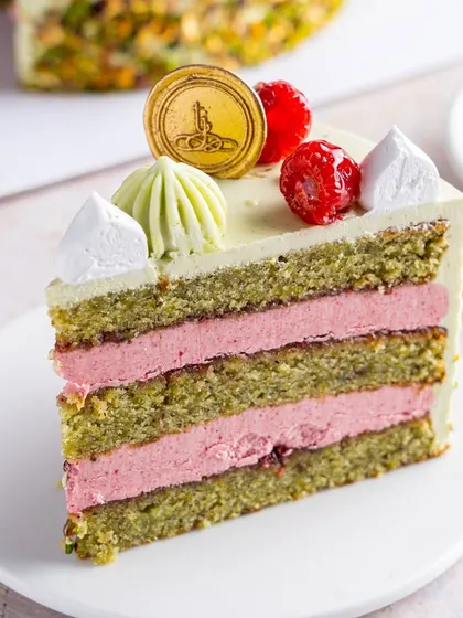 A slice of our Pistachio Raspberry Cake, showing the perfect ratio of moist pistachio sponge to tangy raspberry buttercream. It's a flavour combination that has quickly become a house favourite.