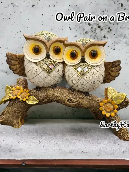 An owl couple on a branch, decorated with mirror work and sunflowers for a unique look.