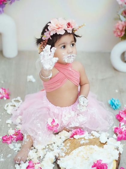 "Look what I did!" This photo perfectly captures the proud and playful aftermath of a successful cake smash.