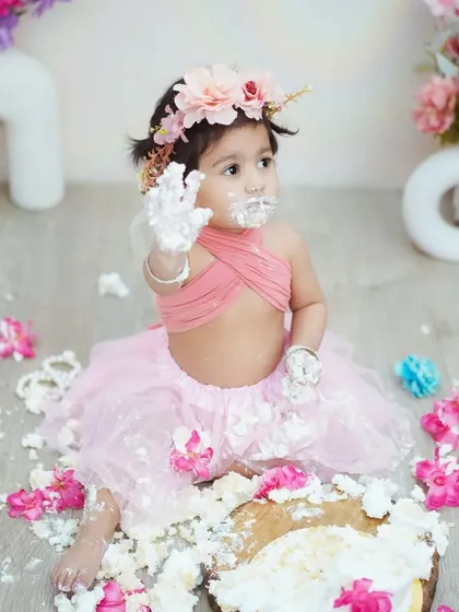 "Look what I did!" This photo perfectly captures the proud and playful aftermath of a successful cake smash.
