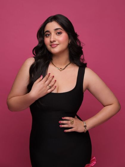 Another shot of Revathi Pillai in the chic black and pink dress, showcasing the jewelry and her confident pose.
