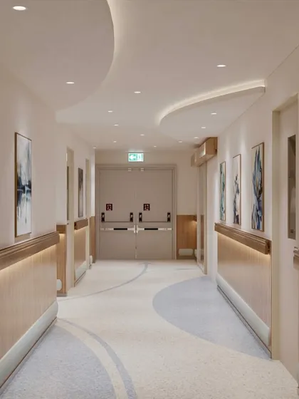 We transform sterile hospital corridors into pathways for healing. This ICU corridor uses gentle, curved ceiling details, soft, indirect lighting along the handrails, and calming wall art to create a soothing journey through the space, reducing the typical anxiety associated with hospital environments.