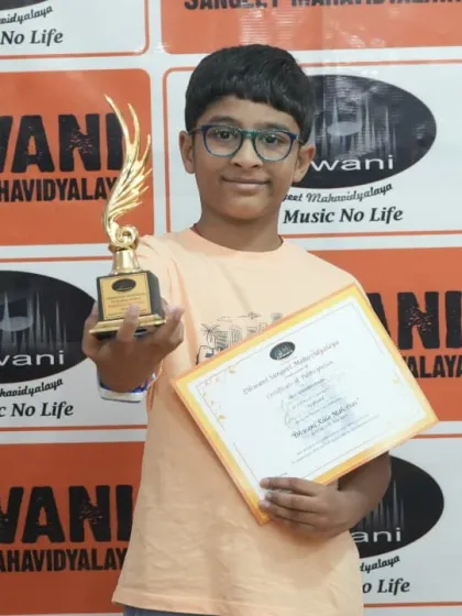 A student smiles as he holds his trophy, a reward for his dedication to sketching.