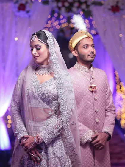 A beautiful portrait of the couple. The bride's diamond set, including the delicate nath, perfectly complements her groom's attire.