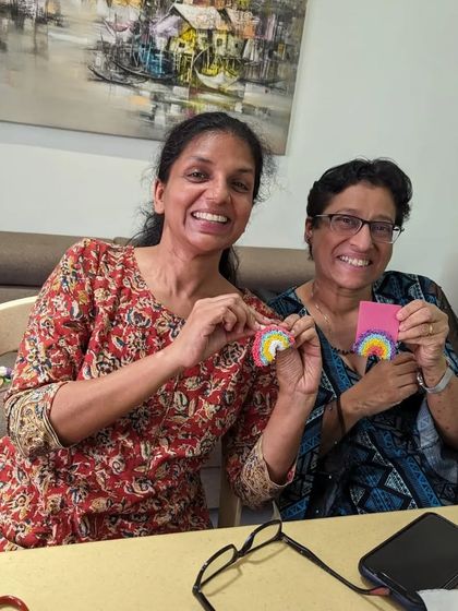A joyful moment captured with two friends and their handmade rainbow charms.
