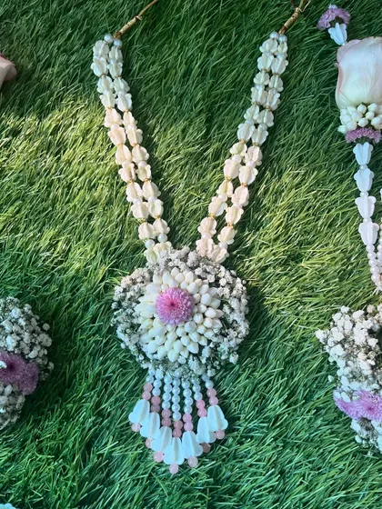 A close-up of the necklace from the pink and purple floral set. The central pendant is made of tightly clustered flowers for a beautiful effect.