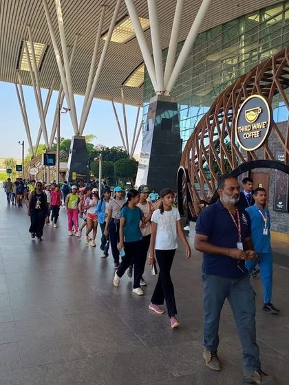 An instructor leads the group of campers on their educational tour of the Bengaluru airport facilities.