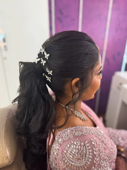 A side view of Surya's modern ponytail, showing the texture and the placement of the butterfly clips. This hairstyle is both chic and playful.