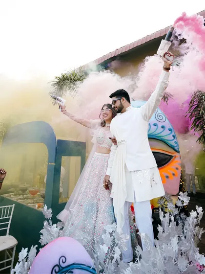 Let the celebrations begin. A Haldi ceremony is full of life, and I love capturing the energy with vibrant shots like this, using color smoke to frame the couple's grand entrance and kick off the festivities with a bang.