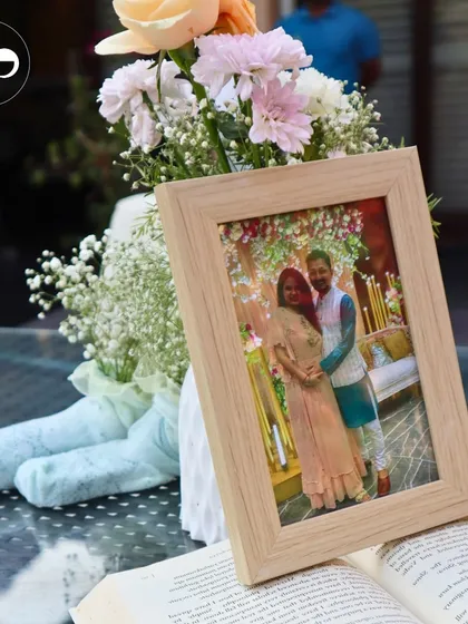 A framed photo of the couple sits on a table next to a floral arrangement, a simple way to personalize the space.