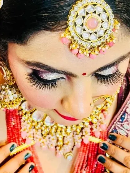 A detailed shot of bridal eye makeup. I used silver and pink glitter eyeshadow with dramatic false lashes to make her eyes pop, complementing her pink-toned jewelry.