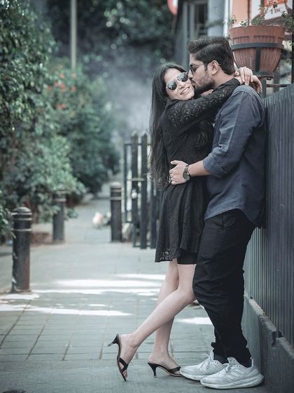 A duplicate of an intimate embrace on a city sidewalk, capturing a tender moment in a casual, urban setting.