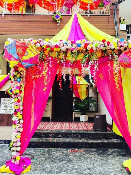 A beautiful entrance canopy decorated with flowers and colourful drapes, creating a perfect welcome for guests.