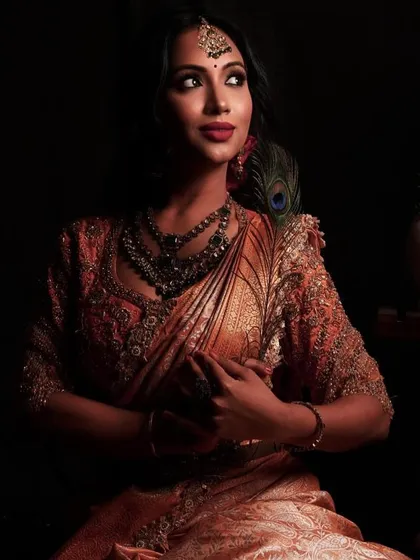A dramatic and beautiful shot for Deepavali. The lighting highlights the rich colours of her saree and the intricate details of the makeup and jewellery.