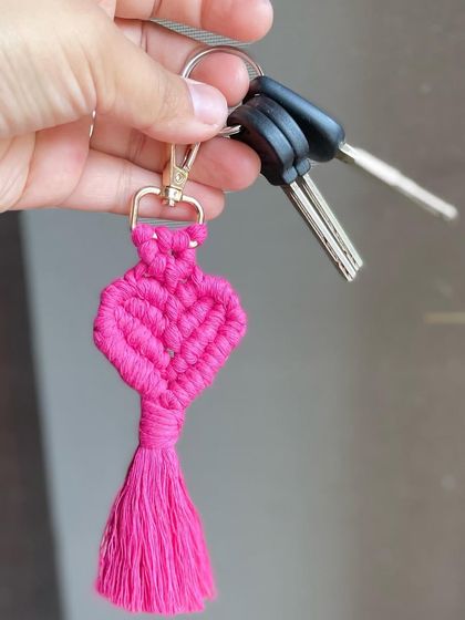 Holding my pink heart keychain, attached to a set of keys to show how it can be used.