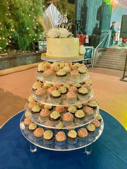 A full view of the 25th-anniversary celebration setup, featuring my custom cake and a tower of matching cupcakes. It creates such a stunning dessert display.