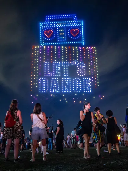 A drone formation of a boombox with the words 'LET'S DANCE' at a music festival. This image is part of my guide for organizers on how to integrate a drone show seamlessly into a live music event.