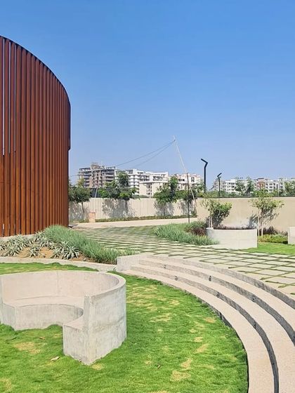 The public seating areas in our Raipur landscape project are designed as simple, monolithic concrete forms that emerge from the green lawn.
