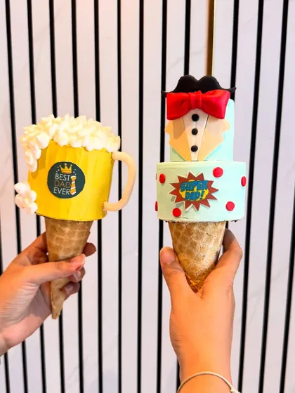 A fun 'Best Dad Ever' beer mug cakesicle alongside a 'Super Dad' tuxedo design. These are perfect, bite-sized treats to celebrate your hero on his special day.