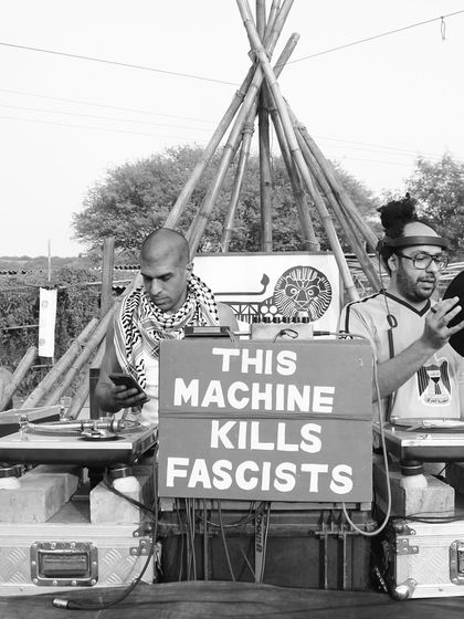 Me and Delhi Sultanate behind the decks for a BFR Sound System session. The sign says it all: "This Machine Kills Fascists." We use music as a tool for unity and expression.