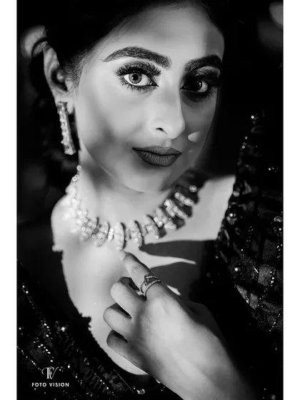 An intense and striking black and white close-up of the bride, with dramatic lighting highlighting her beautiful eyes and jewelry.