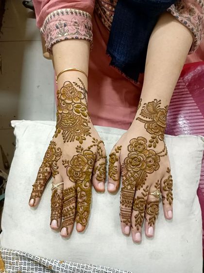 This fusion design combines the flowing vines of Arabic mehendi with detailed patterns on the fingertips, offering a mix of modern and traditional styles.