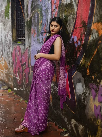 A full-length fashion portrait against a vibrant graffiti wall. This image shows how traditional wear can be styled in a modern, urban environment, creating a bold and artistic statement.