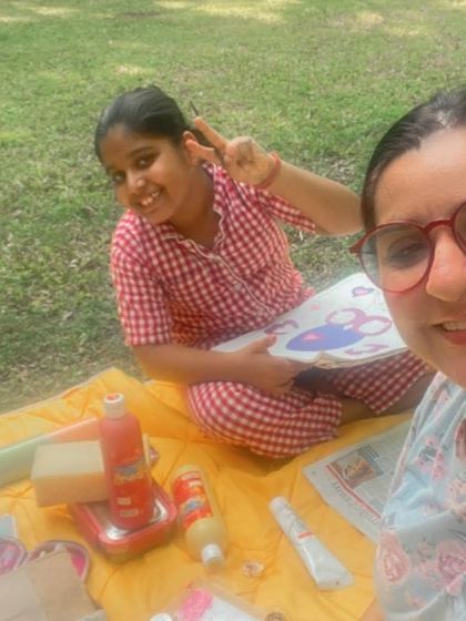 Our pyjamas are perfect for all-day wear, especially in the summer. Here's a girl enjoying a picnic and painting session outdoors in our red woven checks pyjama set.