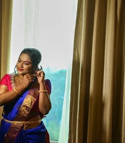 A candid moment of the bride getting ready for her engagement. This photo captures her adjusting her earrings, giving a lovely view of her side profile and elegant updo.