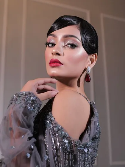 A different angle of the vintage glam look. Her pose and the lighting highlight the sculpted features and the intensity of the eye makeup, creating a truly captivating image.