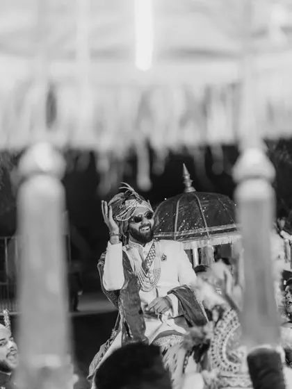 A candid black and white shot of the groom during his baraat, full of energy and joy.