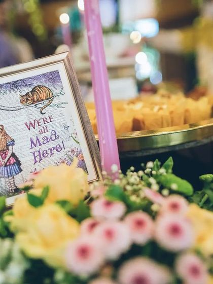 "We're all mad here." I use framed quotes and floral arrangements to create charming, on-theme centerpieces that bring the story of Alice in Wonderland to life on every table.