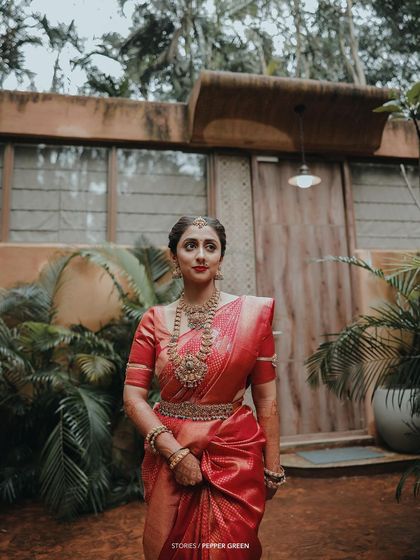 A stunning portrait of the bride in her red saree, her pose elegant and her expression serene.