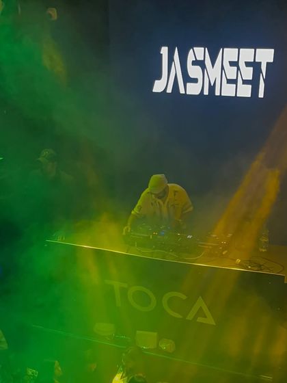 A moody shot from the DJ console at Toca, surrounded by green and yellow smoke.