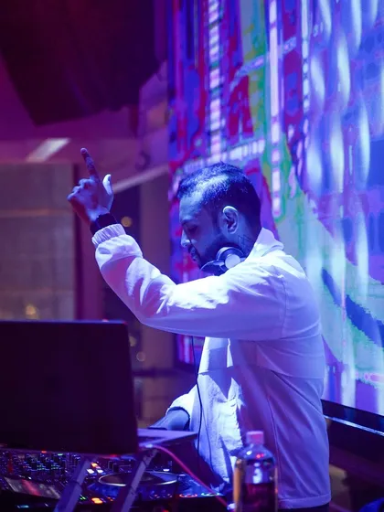 Pointing to the sky, lost in the music. This is me in my element, with the VJ screen creating a stunning backdrop.