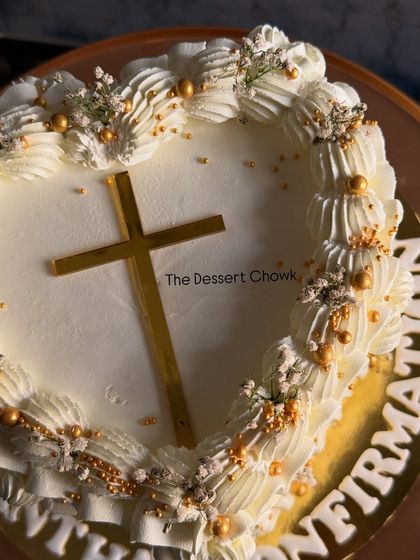 A top-down view of the Confirmation cake, highlighting the beautiful symmetry of the vintage piping design around the golden cross.
