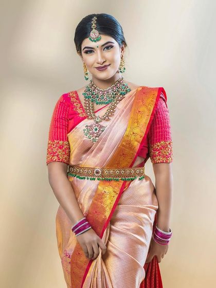 Pinky looking regal in her pink and gold saree. The makeup is bold and defined, perfect for a grand wedding.