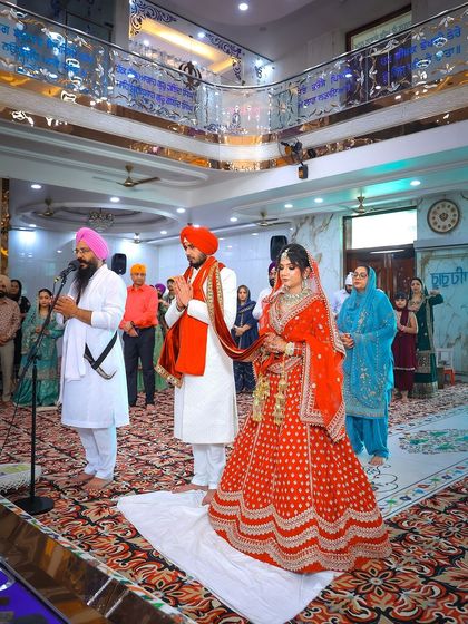 The couple stands before the congregation during their Sikh wedding ceremony.