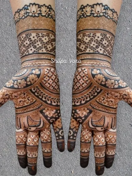 A symmetrical design with a floral wristband and a mix of geometric and leaf patterns on the hand.