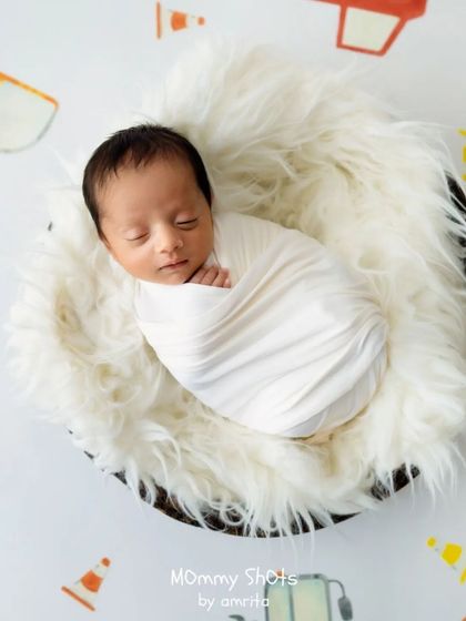 A clean and simple setup using a patterned backdrop and a fluffy white rug to create a modern and fun newborn portrait.
