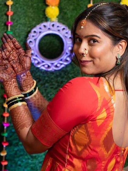 The rich stain of the bridal mehendi looks stunning against the bride's colorful attire.